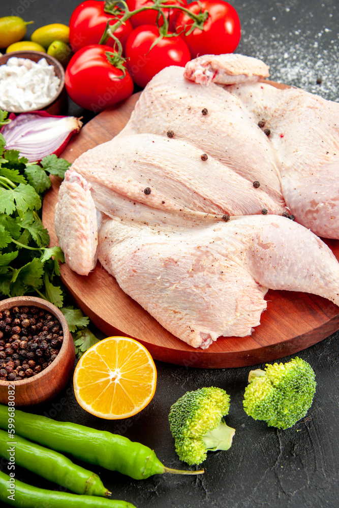 front view fresh raw chicken with greens and red tomatoes on dark background pepper health cooking dish salad food dinner barbecue color front view fresh raw chicken with greens and red tomatoes on dark background pepper health cooking dish salad food dinner barbecue color