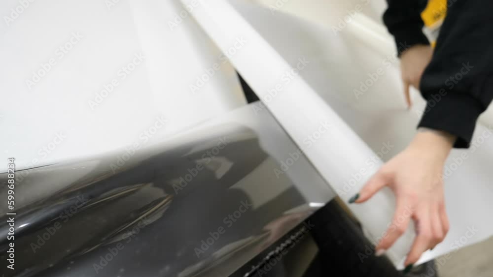 Close up to PPF installation process on a front headlight and hood. PPF