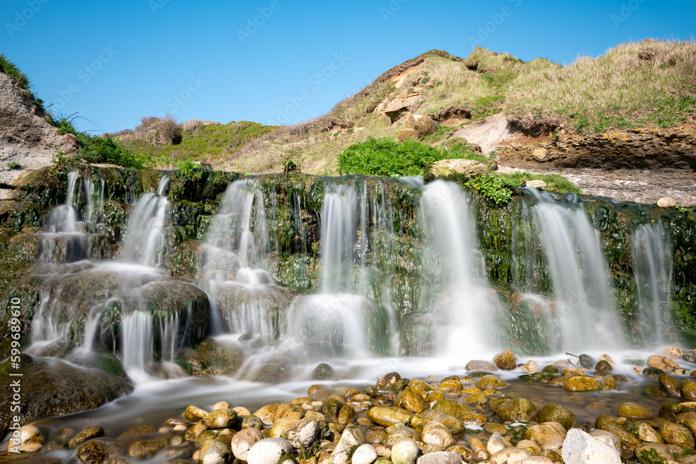 Long exposure of the waterfall flowing onto the beach at Osmington Mills in Dorset Long exposure of the waterfall flowing onto the beach at Osmington Mills in Dorset