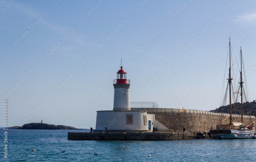 The picturesque Ibiza lighthouse surrounded by water, sky, and seagulls