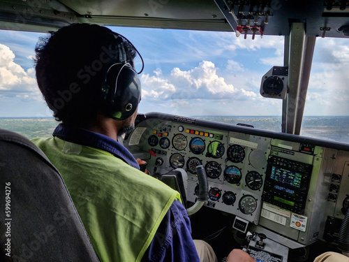 Pilot beherrscht die Cockpitinstrumente einer Gippsland GA-8 Airvan Propellerflugzeug / Kleinflugzeug über Botswana, Afrika photo