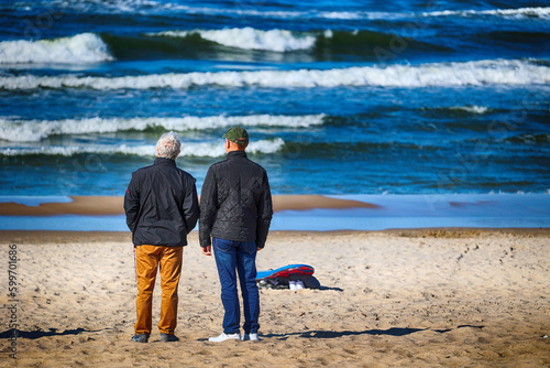 Ciepło ubrani ludzie na plaży nad morzem wiosną. 