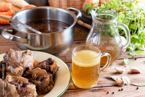 Transparent Cup of bone broth is placed on boiled beef bones, which contain the necessary amino acids for the body.