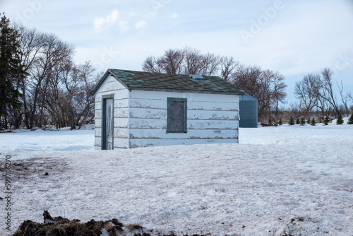 dilapidated building on farmstead in north dakota in winter with blue skies