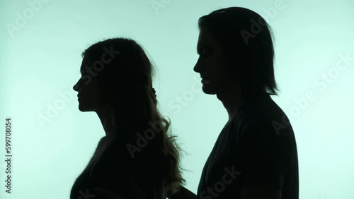 Silhouettes of a girl and a man who love each other on an isolated light green background with a copy of the text space.