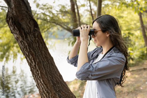 Female Using Binoculars to Watch Birds in a Lagoon © jorge