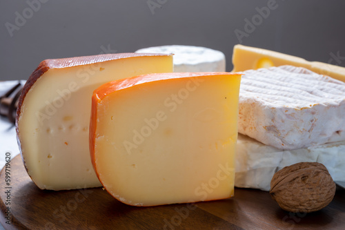 Collection of Belgian cheeses, soft yellow cow milk cheese with white mold from Bruges, bouquet des moines from Abbey of Val-Dieu, creamy cheese and beer cheeses photo