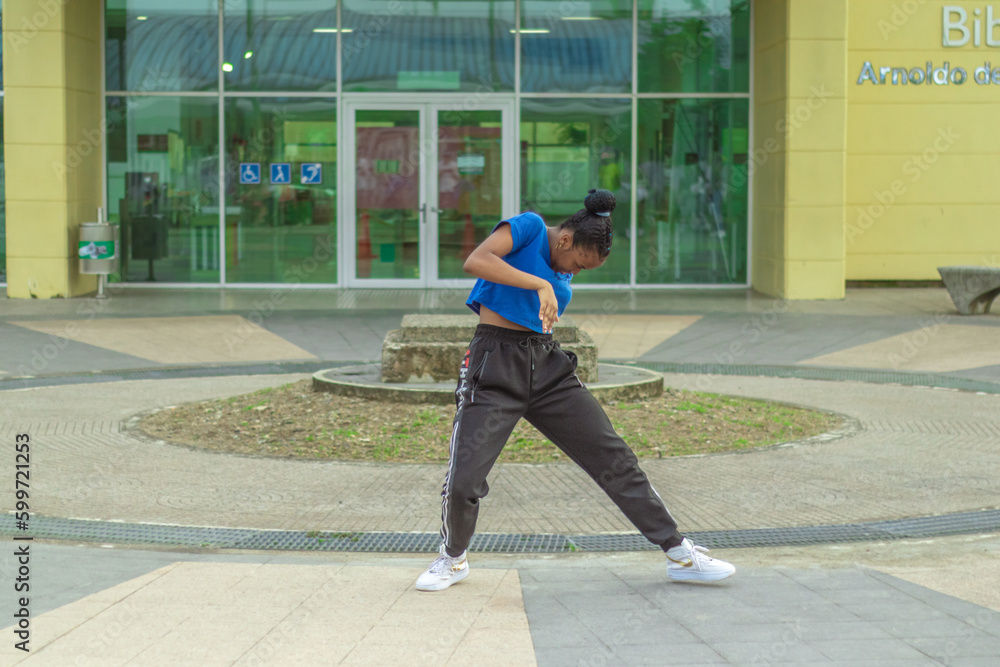 Joven Afro baila al estilo urbano en el centro de la ciudad