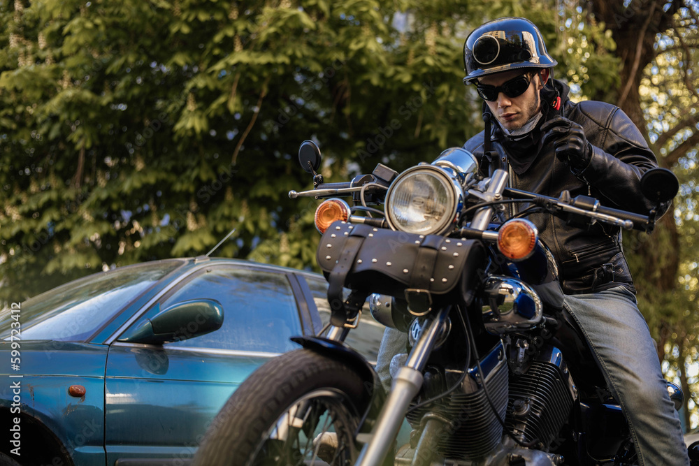 Biker in a helmet and glasses on a chopper motorcycle with a wardrobe trunk Biker in a helmet and glasses on a chopper motorcycle with a wardrobe trunk