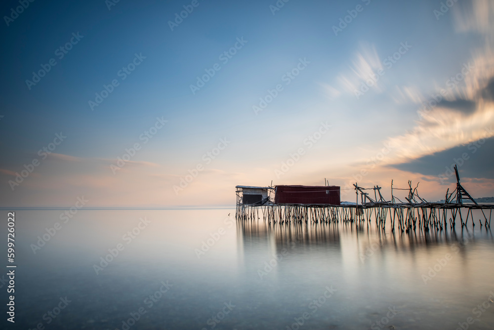 wooden piers built into the sea and helping fishing, and the sunset colors and light wooden piers built into the sea and helping fishing, and the sunset colors and light