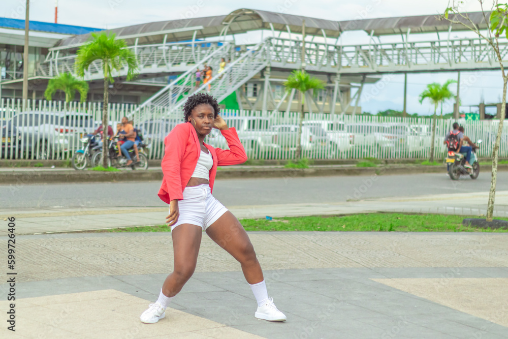 Obraz premium Joven Afro baila al estilo urbano en el centro de la ciudad