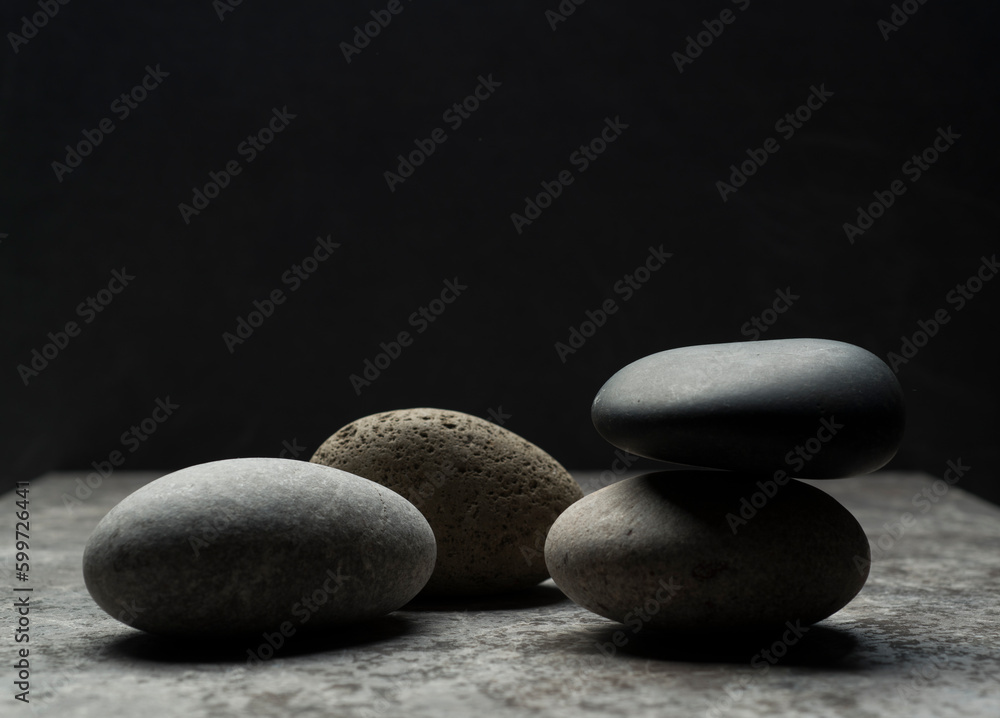 gray zen stones on a dark gray background with shadows for a podium background.a group of oval stones for product presentation gray zen stones on a dark gray background with shadows for a podium background.a group of oval stones for product presentation