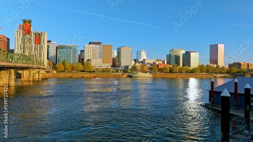 Golden hour hover and flyover and rise-up aerial view over the Willamette River next to the Hawthorne Bridge, downtown Portland, Oregon, with River Cruise Ship, and Scenic City Landmarks