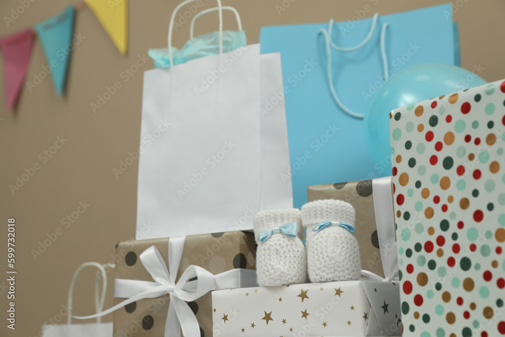 Baby shower party. Booties, many gift boxes and bags indoors Baby shower party. Booties, many gift boxes and bags indoors