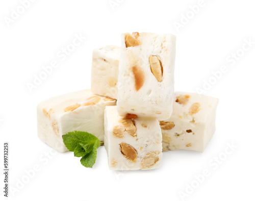 Pieces of delicious nougat and mint on white background photo