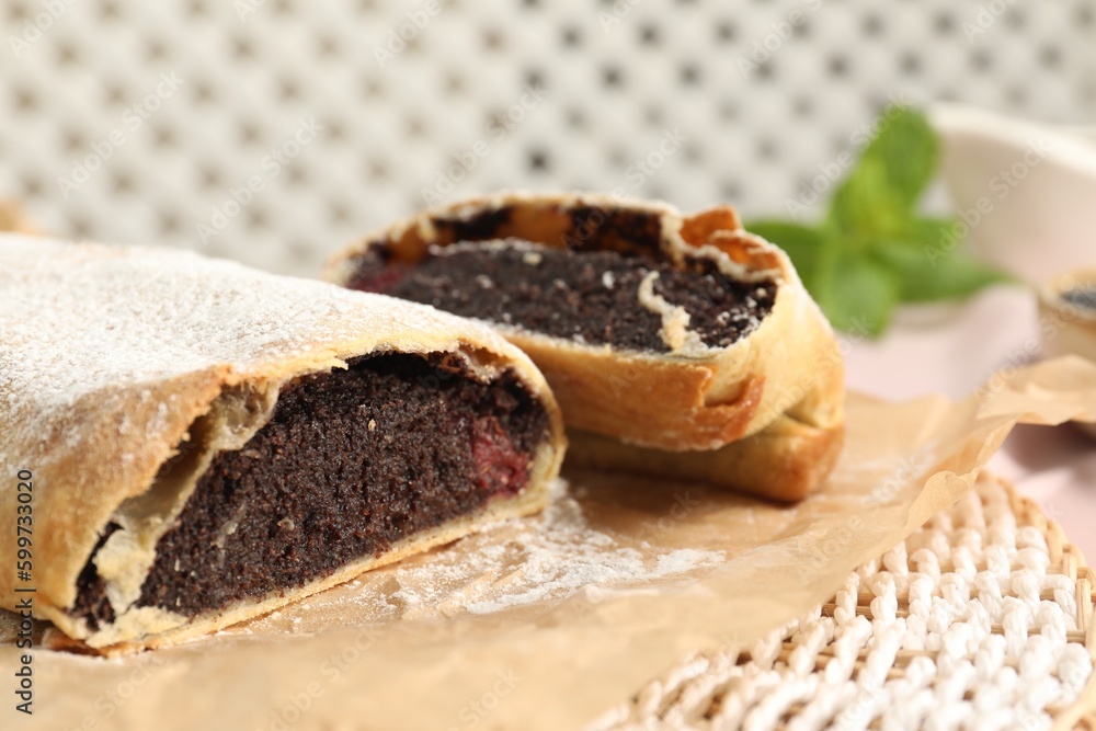 Delicious strudel with poppy seeds and cherries on mat, closeup Delicious strudel with poppy seeds and cherries on mat, closeup