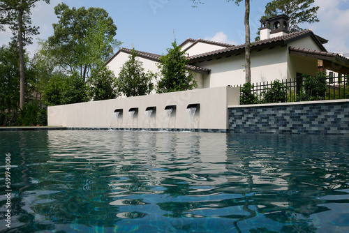 Obraz na plátne THE WOODLANDS, TEXAS - MAY 5th 2023: an outdoor pool and spa with water features on a hot sunny day