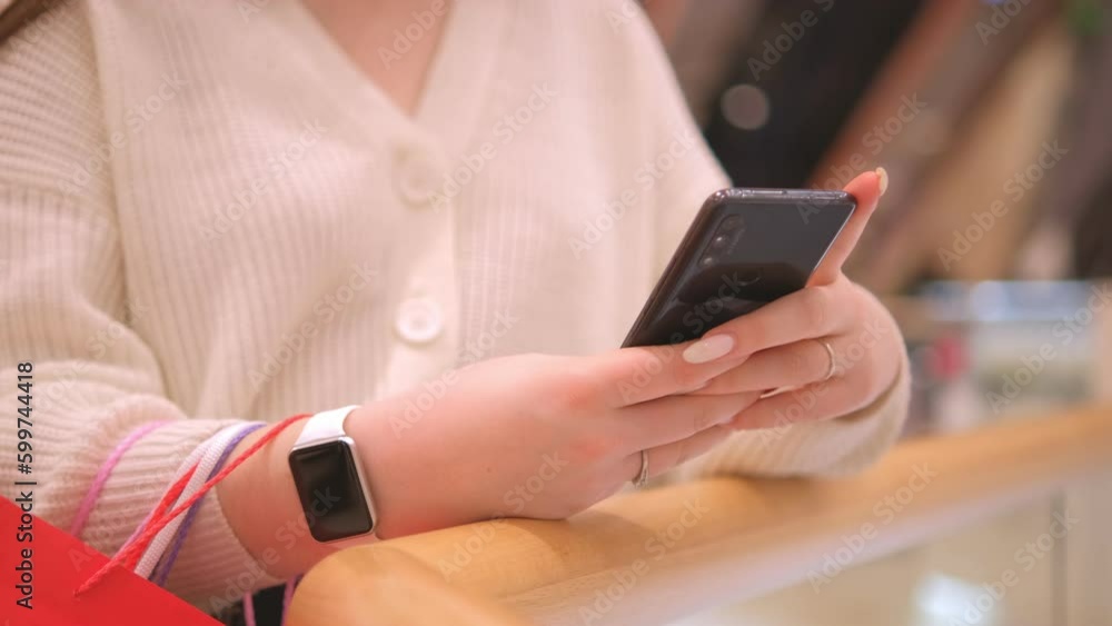 Young woman using smartphone at mall. Caucasian girl looking at mobile phone in her hand. Communication, connection, mobile apps, technology, lifestyle concept 4K Young woman using smartphone at mall. Caucasian girl looking at mobile phone in her hand. Communication, connection, mobile apps, technology, lifestyle concept 4K