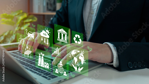 Businessman analyze investment sustainability ESG icons. ESG environmental protection concept, sustainable development, climate change, green energy recycle, Net zero and carbon neutral. photo