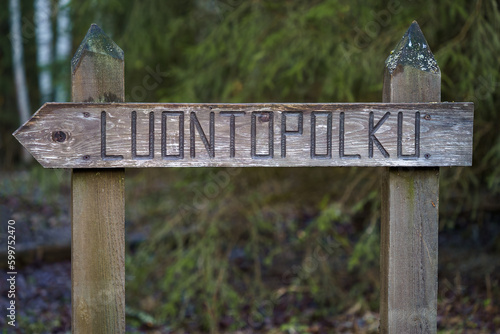 Wooden sign in the woods with the word luontopolku (nature trail) photo