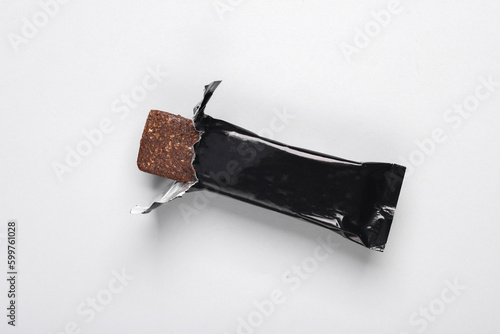 Black packaging of a chocolate or protein bar on gray background