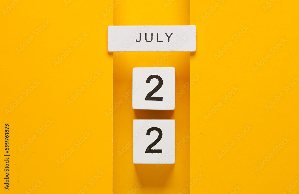 White calendar cubes with date july 22 on yellow background. Creative layout White calendar cubes with date july 22 on yellow background. Creative layout