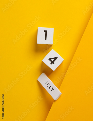 White calendar cubes with date july 14 on yellow background. Creative layout