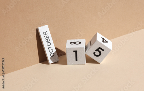 Wooden white block calendar with date october 15 on beige background with shadow. Creative layout, planning, holiday