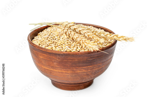 Ears of wheat on bowl with wheat. Isolated on white.