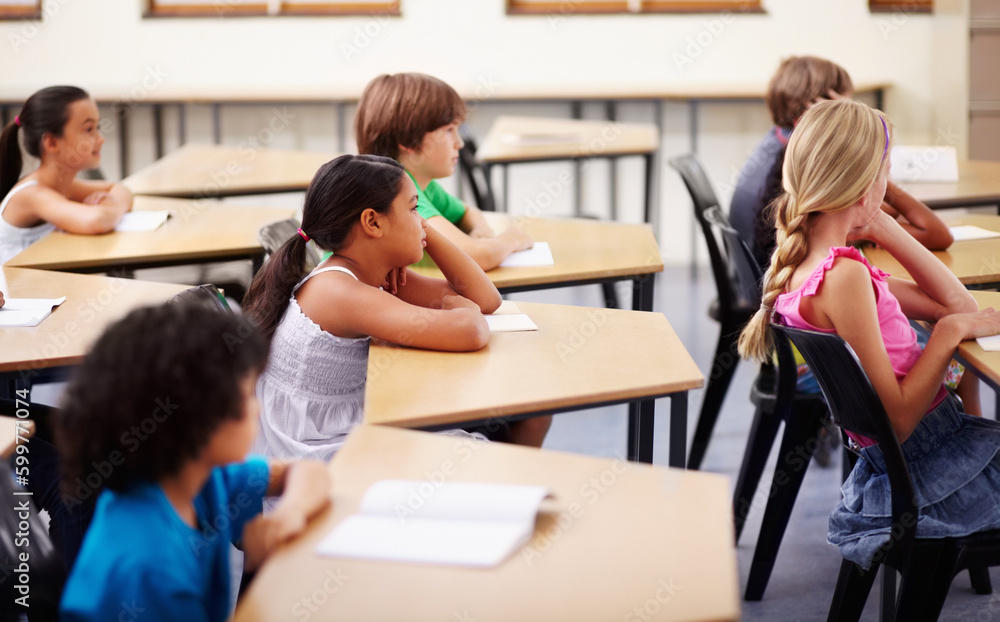 Obraz premium Education, learning and children in classroom with focus, attention and study at Montessori school. Group of students at desk studying, child development and kids with concentration in lesson or test