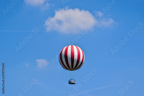 Photography red and white gas filled huge balloon against blue sky in Budapest, city park