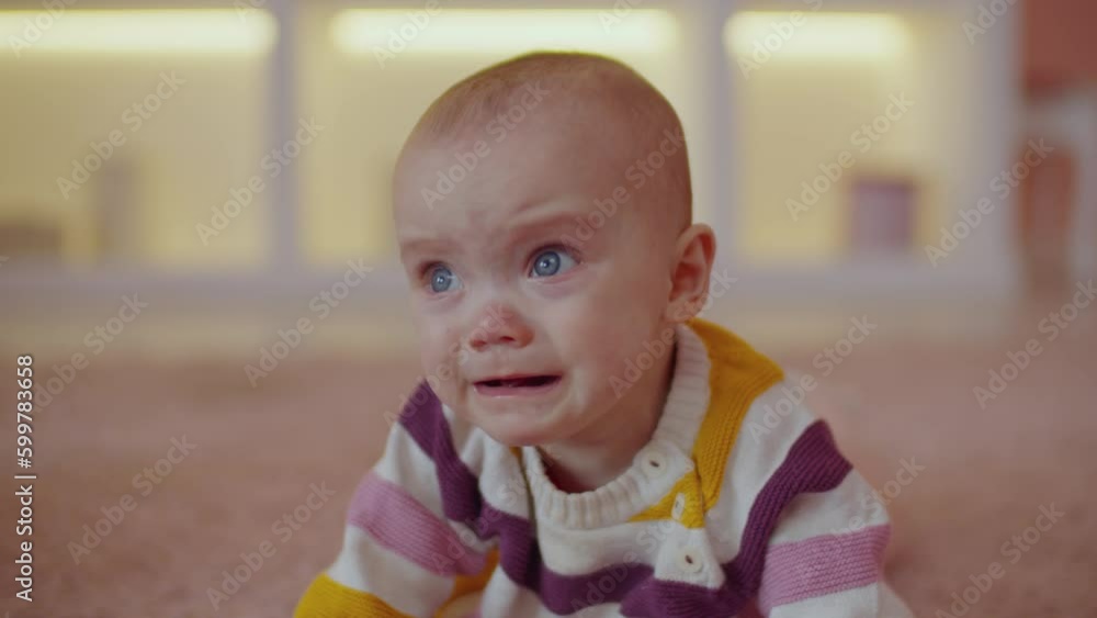 Portrait of upset adorable infant baby girl with blue eyes almost crying, looking with confused stare, expressing negative emotions and worries while lying on floor at home. Portrait of upset adorable infant baby girl with blue eyes almost crying, looking with confused stare, expressing negative emotions and worries while lying on floor at home.