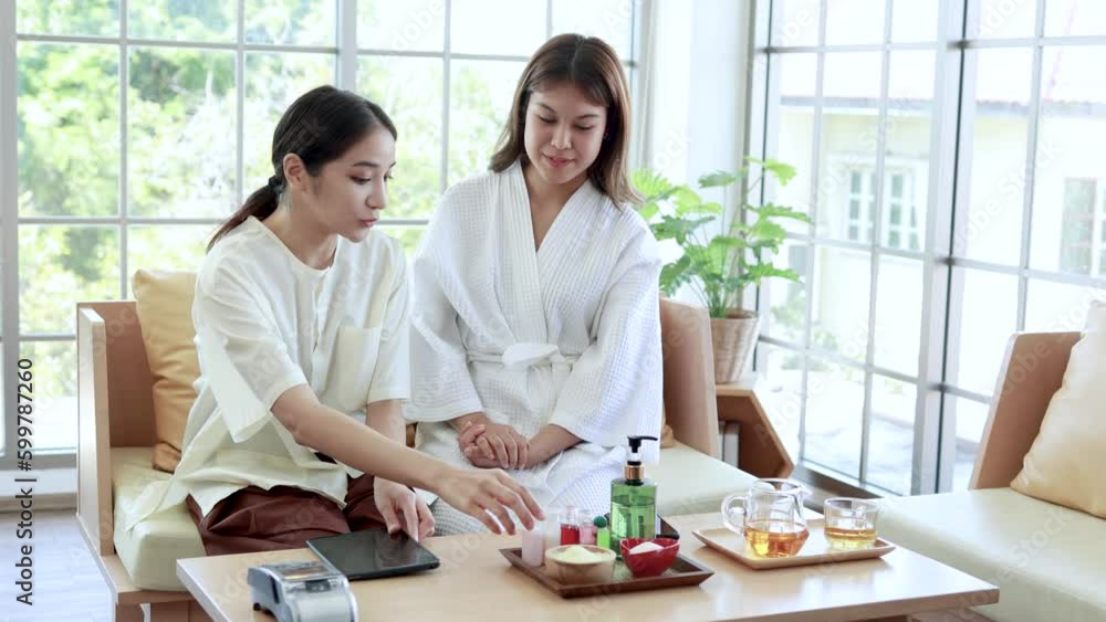female employee recommended Spa packages with young Asian clients and Smartphone payment, Asian woman paying for beauty spa services, smart phone female employee recommended Spa packages with young Asian clients and Smartphone payment, Asian woman paying for beauty spa services, smart phone