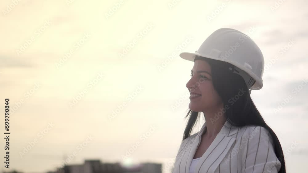 Young pretty girl in construction helmet shows OK sign with her fingers against background of modern line and mountain landscape. She smiles and looks at camera. advertising. Young pretty girl in construction helmet shows OK sign with her fingers against background of modern line and mountain landscape. She smiles and looks at camera. advertising.