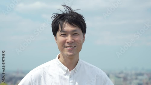 空と白シャツと笑顔の男性