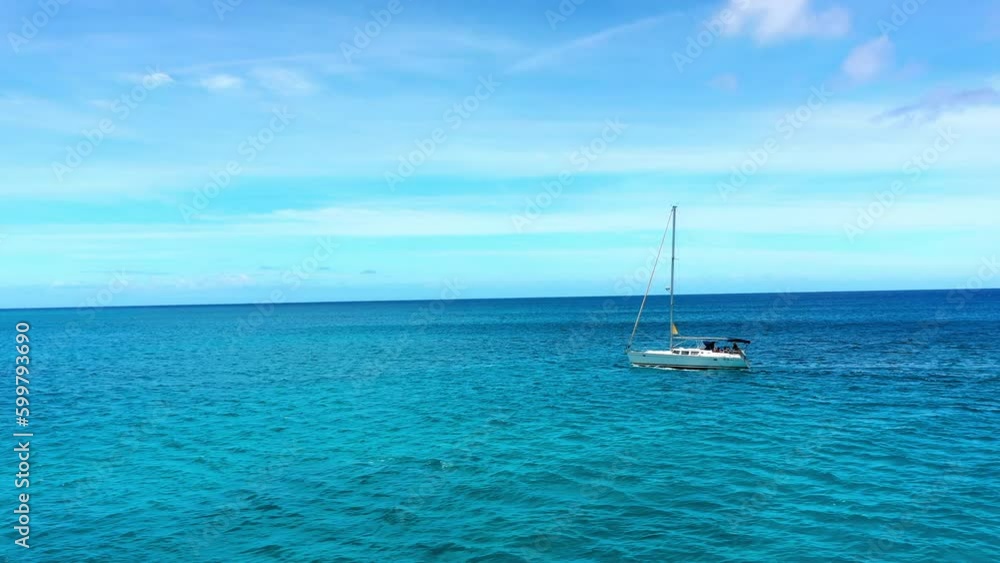 Aerial Panning Shot Of Sailboat Moving On Blue Wavy Sea Under Sky During Sunny Day - Oahu, Hawaii Aerial Panning Shot Of Sailboat Moving On Blue Wavy Sea Under Sky During Sunny Day - Oahu, Hawaii