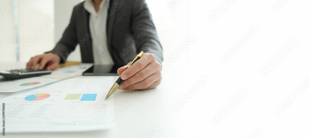 businessman or accountant working on calculator and laptop computer to calculate business data during using accountancy document at office. businessman or accountant working on calculator and laptop computer to calculate business data during using accountancy document at office.