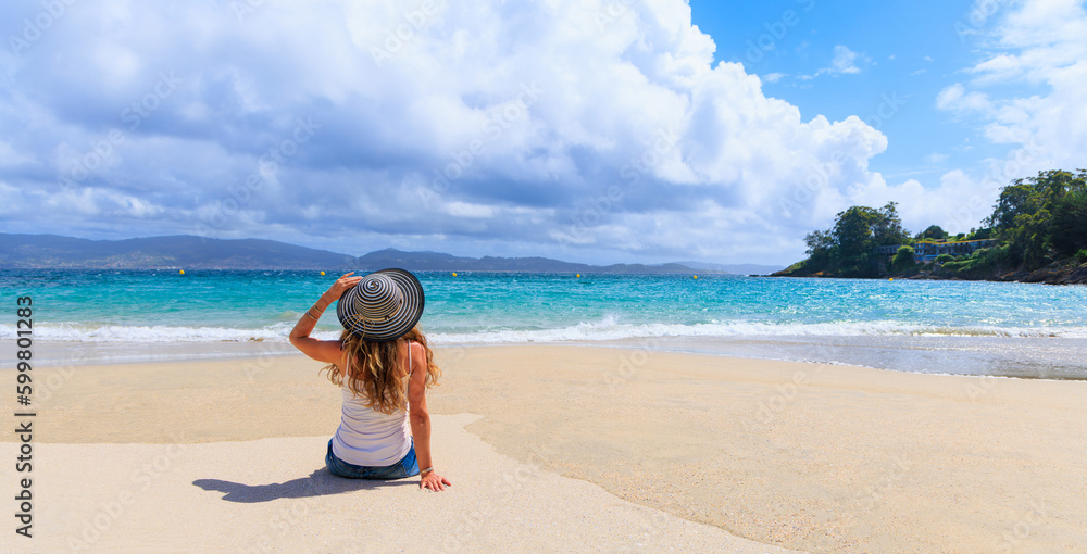 Woman sitting on the beach looking at panoramic view of beautiful atlantic ocean- Galicia in Spain - obrazy, fototapety, plakaty 