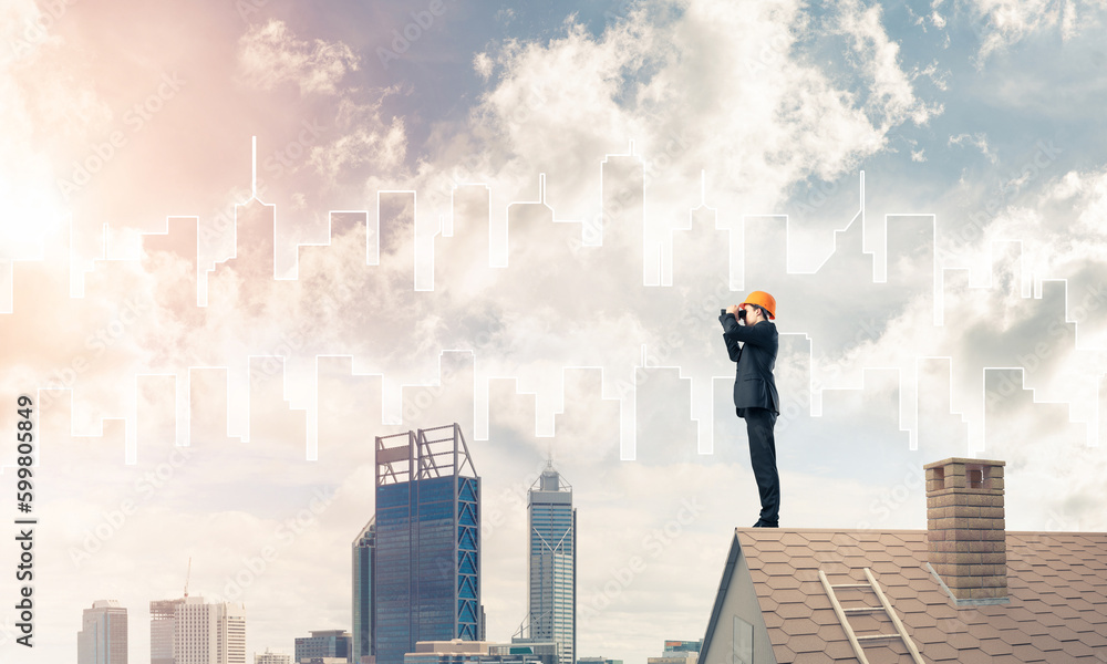 Engineer man standing on roof and looking in binoculars. Mixed m Engineer man standing on roof and looking in binoculars. Mixed m