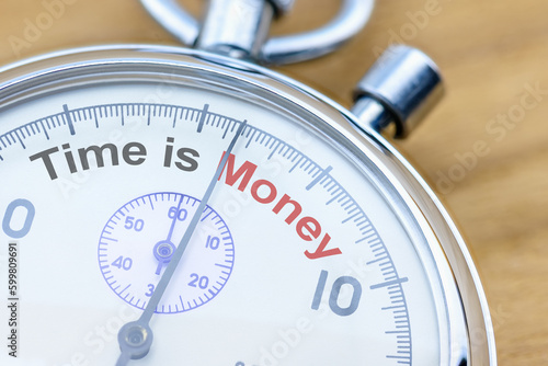 Time is money, financial concept : Closeup of a stopwatch with the word Time is Money. Time is a valuable resource, and wasting time is the same as wasting opportunity to earn money or achieve goals.