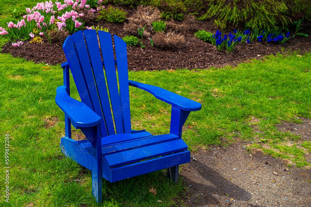 Blue Adirondack Chair in front of flower garden of Sherbrooke City Hall in Canada