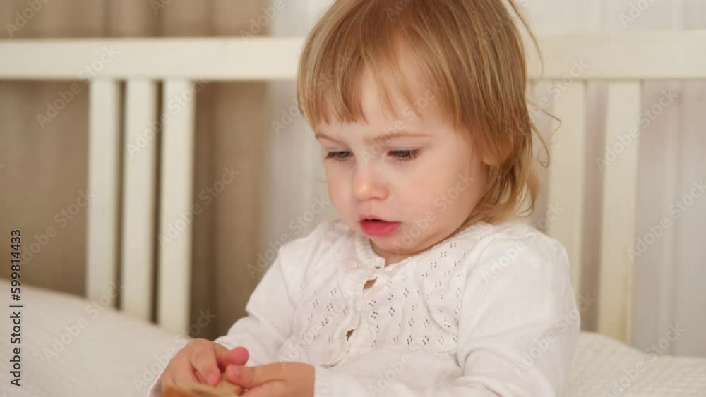 Cute baby girl playing tactile wooden and silicone toys. Young child hand plays sensory massage ball. Enhance the cognitive, physical process. Brain development. Teething toy. Dentition. Baby's teeth Cute baby girl playing tactile wooden and silicone toys. Young child hand plays sensory massage ball. Enhance the cognitive, physical process. Brain development. Teething toy. Dentition. Baby's teeth