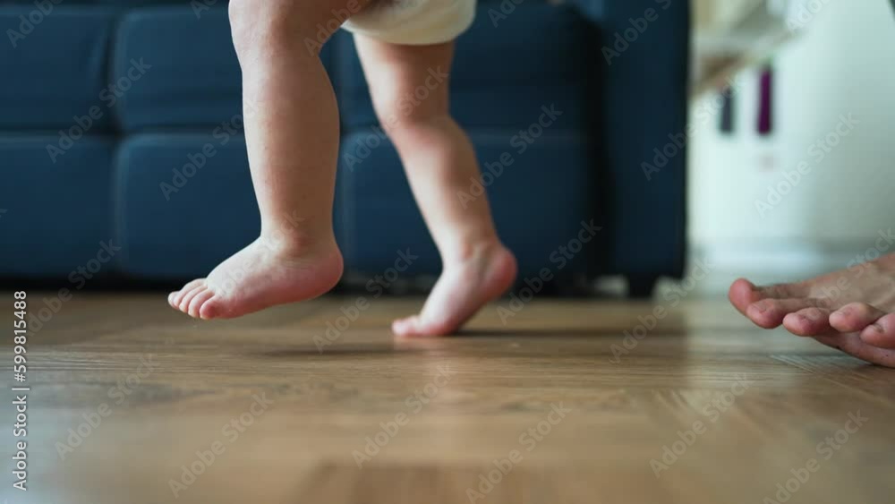 Vidéo Stock Father helps his son take his first steps on parquet floor ...