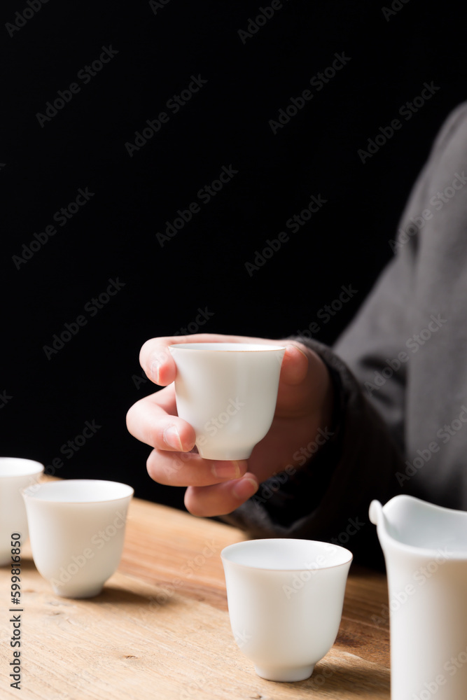 White ceramic teacup in Jingdezhen, China, on wooden table, indoor dark background,traditional chinese tea set White ceramic teacup in Jingdezhen, China, on wooden table, indoor dark background,traditional chinese tea set