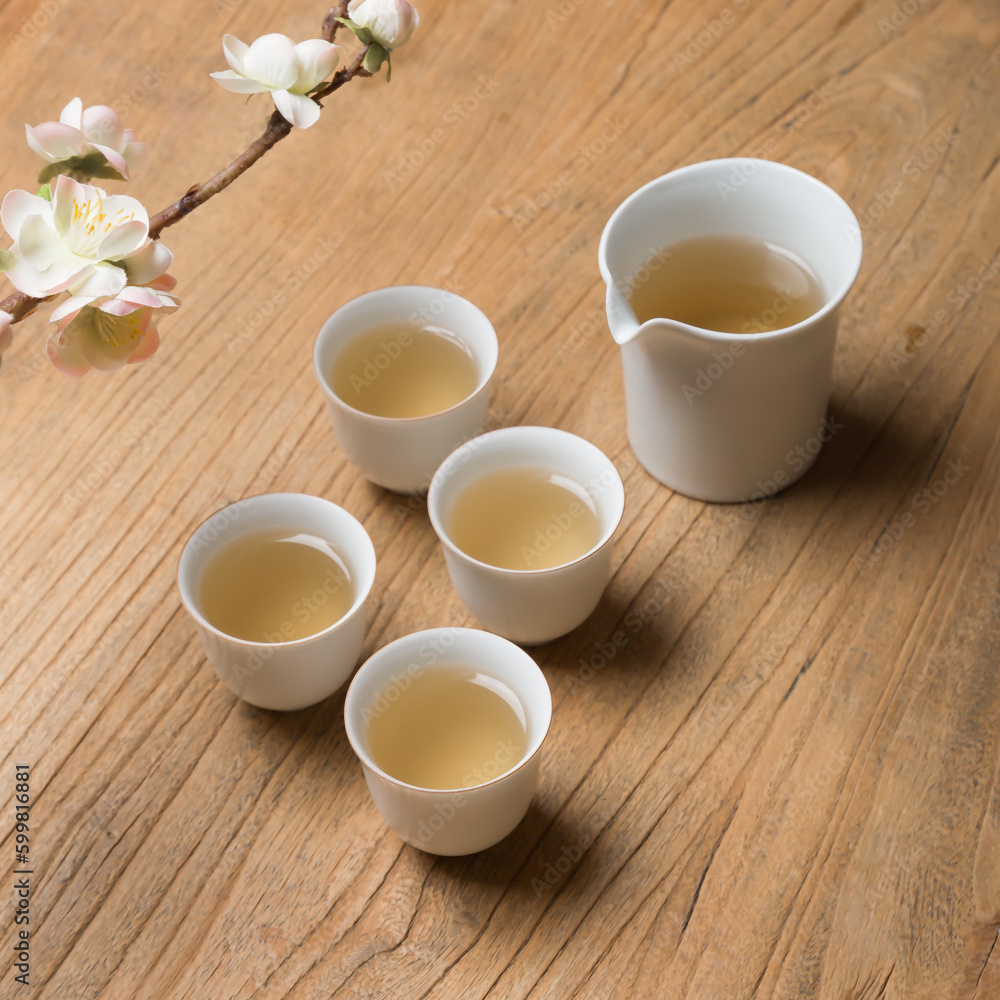 White ceramic teacup in Jingdezhen, China, on wooden table, indoor dark background,traditional chinese tea set White ceramic teacup in Jingdezhen, China, on wooden table, indoor dark background,traditional chinese tea set