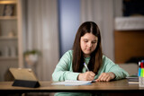 Little girl doing homework with digital tablet. Elementary school student studying online