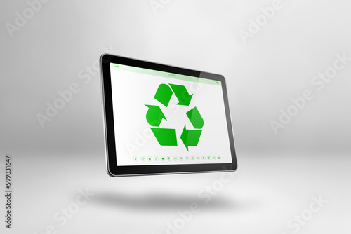 Digital tablet PC with a recycling symbol on screen. environmental conservation concept © daboost
