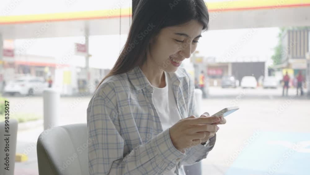 Asian women using smartphone to send text message, read message, playing social media in coffee shop. wireless technology 5G.