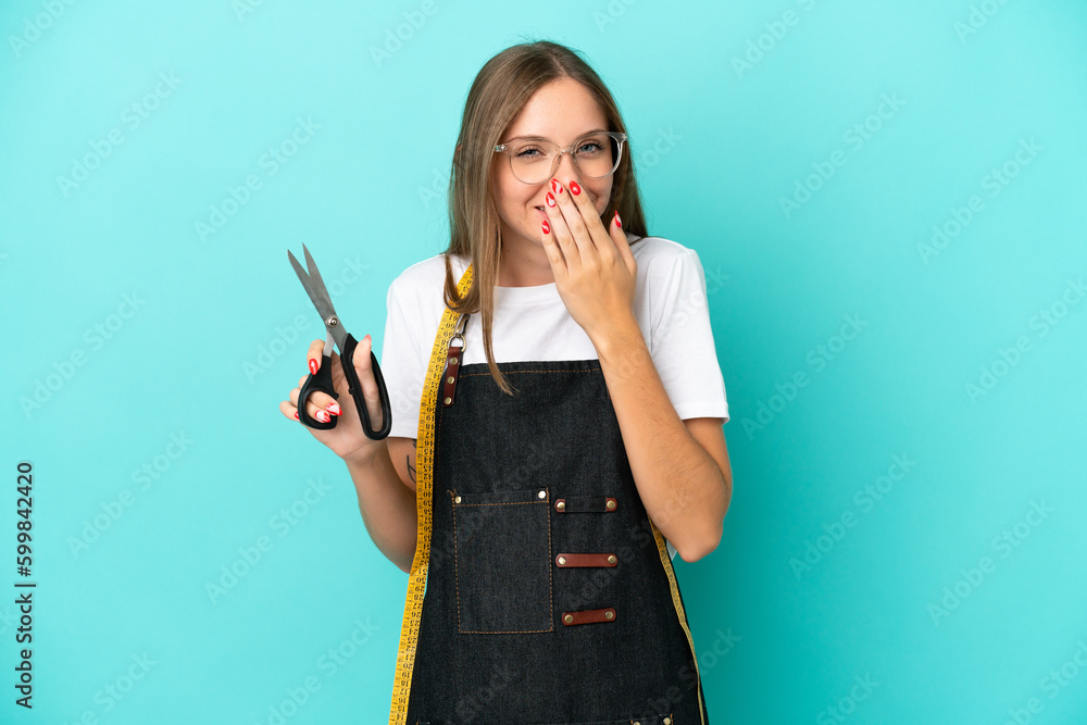Young Lithuanian seamstress woman isolated on blue background happy and smiling covering mouth with hand Young Lithuanian seamstress woman isolated on blue background happy and smiling covering mouth with hand