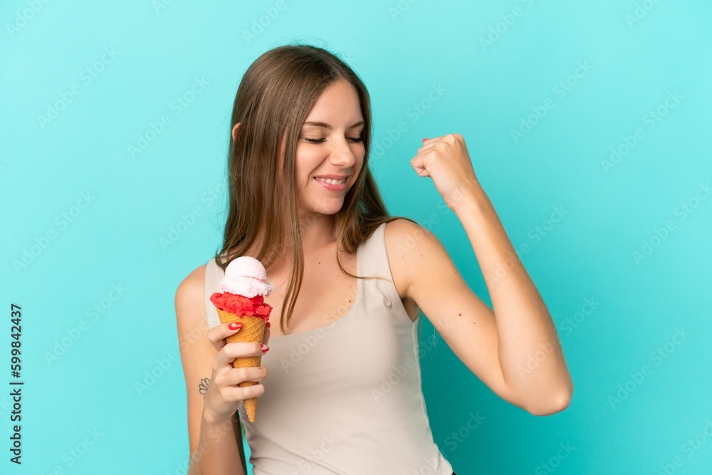 Young Lithuanian woman with cornet ice cream isolated on blue background celebrating a victory Young Lithuanian woman with cornet ice cream isolated on blue background celebrating a victory